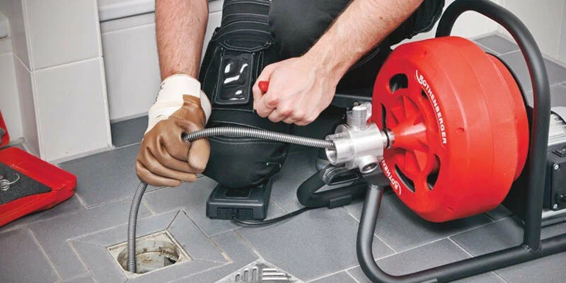 Plumber using a drain-cleaning machine in Winter Springs